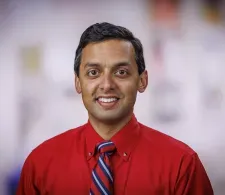 Headshot of Dr. Rahul Banerjee in a clinical setting. He is smiling facing forward