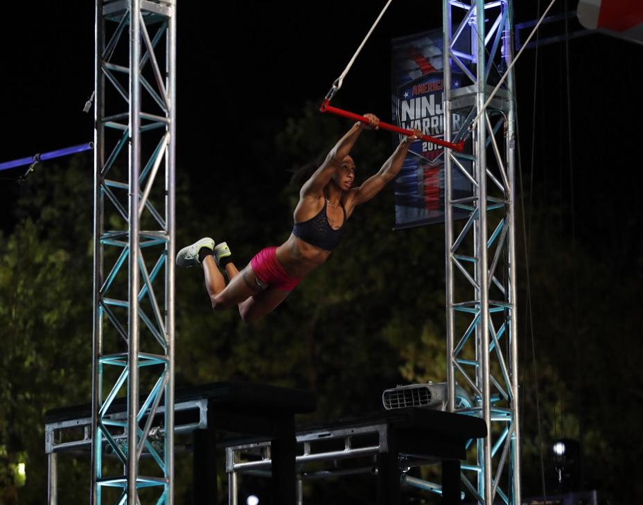 Favia Dubyk hanging from an obstacle swing on American Ninja Warrior