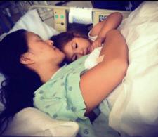 Mai in a hospital bed, sleeping next to her daughter, Angelina.