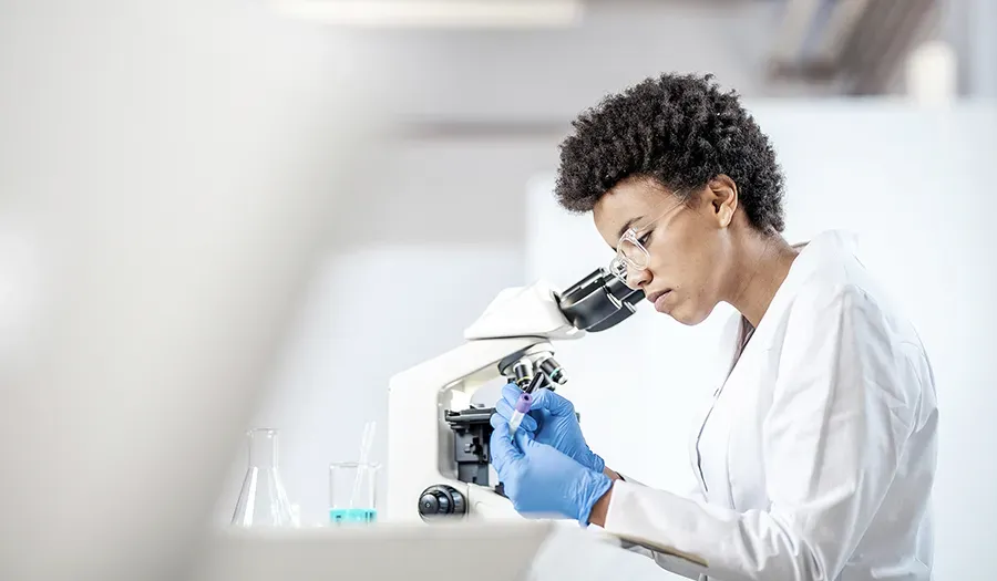 Scientist looking at vial of blood