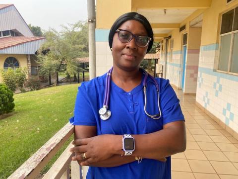 Dr. Kouya Francine, smiling facing forward. She is wearing a blue shirt and stethoscope.