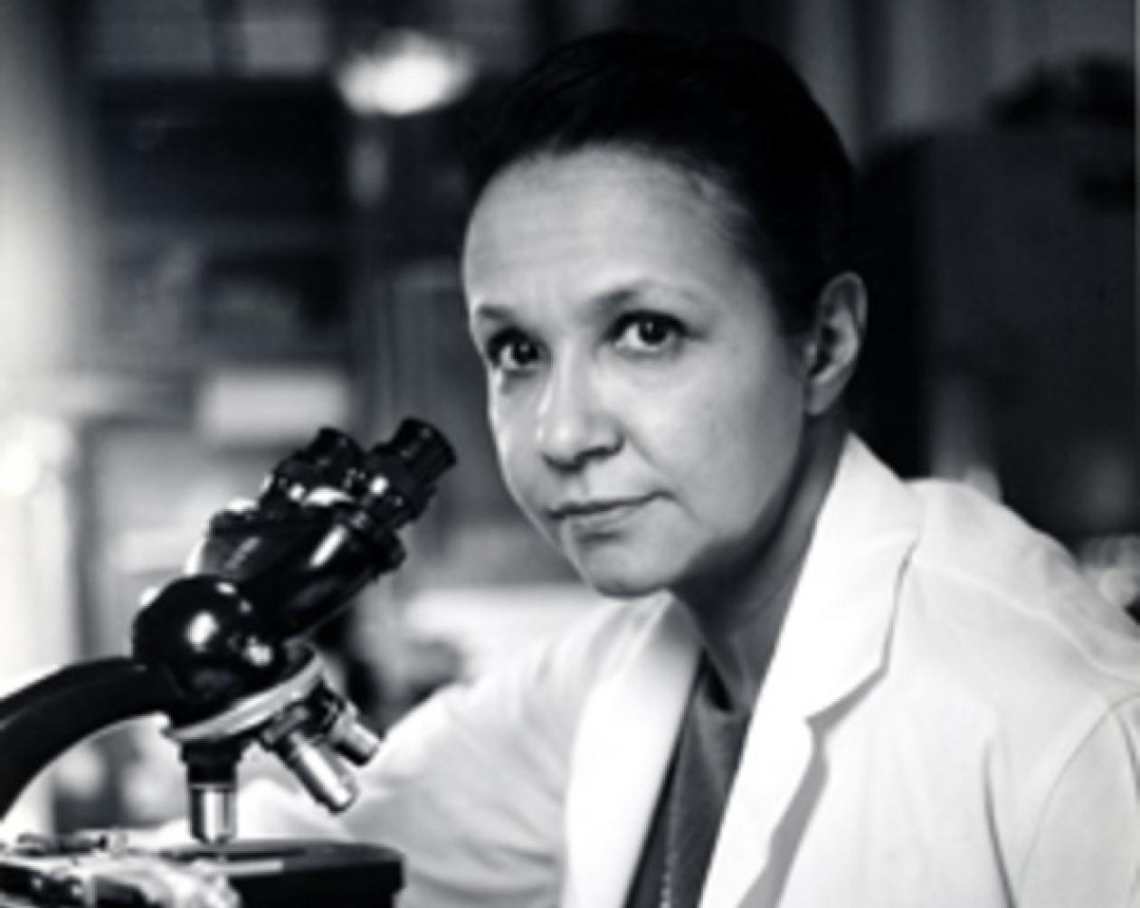 Dr. Jane C. Wright in a lab coat using a microscope to conduct clinical research