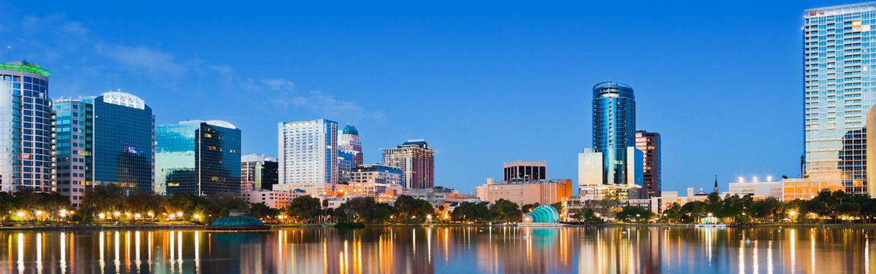 View of Orlando skyline in early evening, city lights glistening in the distance.