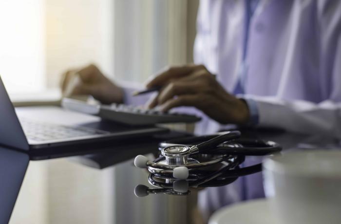 hands typing and stethoscope