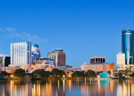 View of Orlando skyline in early evening, city lights glistening in the distance.