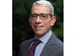 Dr. Eric P. Winer headshot. He is smiling facing forward. He has white hair, is wearing glasses, and is in a gray suit.