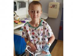 Cain, a 12-year-old patient with Ewing sarcoma, wearing a hospital gown and facing forward