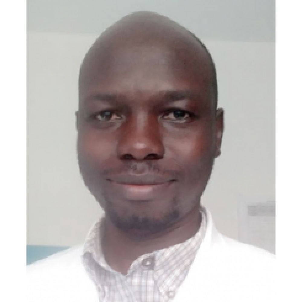 Headshot of Dr. Clement Dove Okello. He is wearing a white coat and is smiling facing forward.