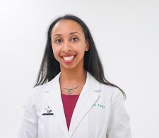 Dr. Favia Dubyk in a white coat. She is smiling facing forward against a clear background.