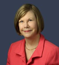 Dr. Sandra Swain headshot. She is smiling facing forward against a dark-gray background.