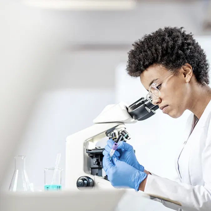 Scientist looking at vial of blood